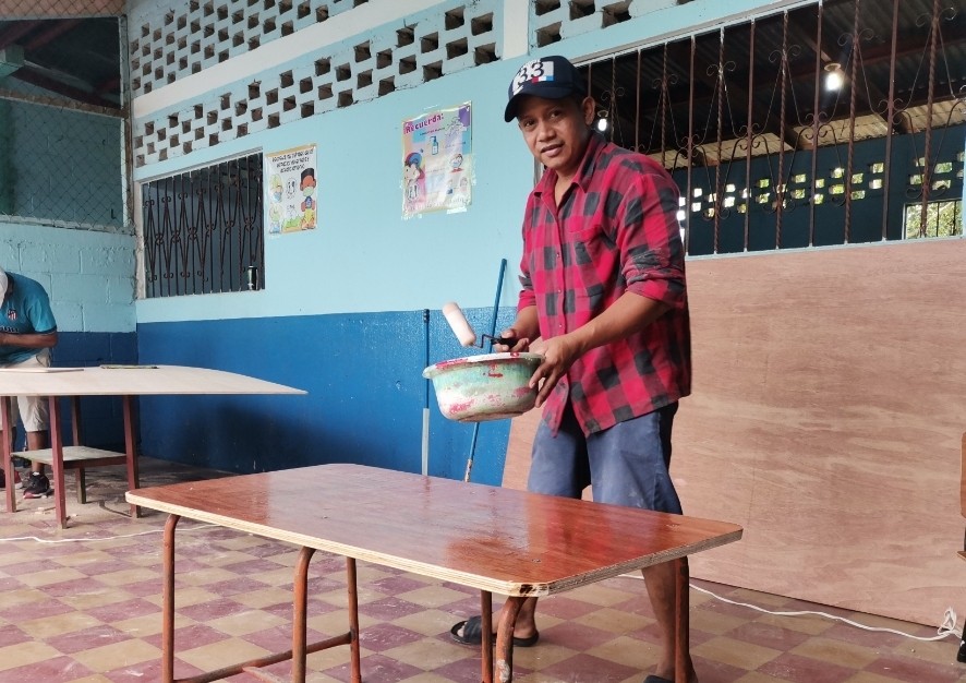 Reparan escritorios de una escuela pública con el apoyo de migrantes